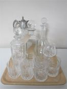 A tray containing a cut glass and plated claret jug, three decanters,