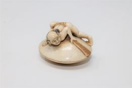 A Japanese ivory netsuke depicting a man on a clam shell, Meiji period,