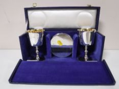 A pair of silver goblets and matching silver coasters, cased.
