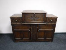 An early 20th century carved oak cocktail sideboard