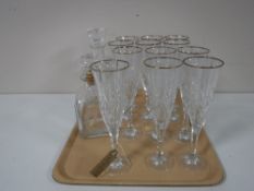 A tray containing a set of twelve gilt rimmed champagne flutes,