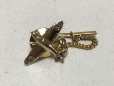 A 9ct gold spit fire tie pin on gilt mount