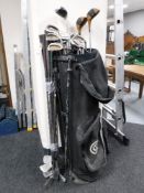 A golf bags containing various irons and drivers and a bundle of irons
