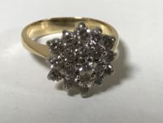 An 18ct gold diamond cluster ring set with 19 brilliant cut stones,