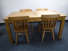 A rectangular pine kitchen table together with four chairs