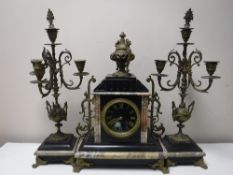 A three piece black slate and marble French clock garniture