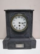 A late nineteenth century black slate mantel clock with enamelled dial
