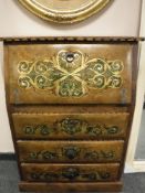 A bureau with decorative metal stud work and scroll design,