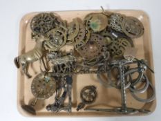 A tray of assorted horse brasses, brass ornaments, horse bit,