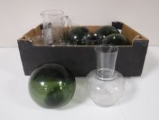 A box containing four green glass hand blown balls, together with an etched glass decanter,