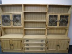A 20th century blonde oak triple section bookcase fitted cupboards beneath