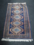 A fringed woolen rug of geometric design on blue ground