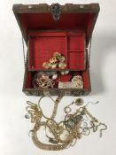 A casket jewellery box containing assorted costume jewellery including two gold and silver rings,