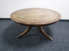 A circular mahogany coffee table on brass inlaid pedestal