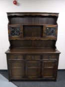 A carved oak triple door kitchen dresser