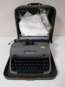 A cased Remmington typewriter and a bag of table linen
