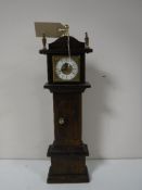An oak cased miniature grandfather clock
