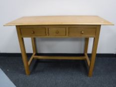 A contemporary oak side table fitted 3 drawers