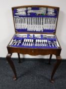 A walnut cutlery table containing a set of Viners stainless steel cutlery