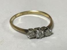 An 18ct gold three stone diamond ring, size N/O, 1.5g.