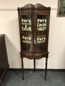 A pair of mahogany glazed bow fronted cabinets on stands ' Fry's Milk Chocolate', height 165 cm.