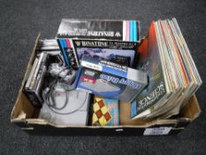 A box containing a Playstation with controller and a small quantity of games,