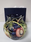 A Moorcroft vase decorated with tubelined floral decoration, boxed.