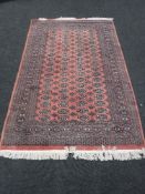 A fringed woolen rug on pink ground