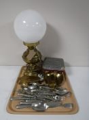 A tray containing a brass oil lamp with glass shade, converted, assorted table cutlery,