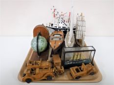 A tray containing wooden bookends, wooden fishing trawler, pond yacht, wooden cars,