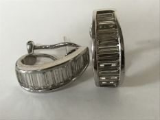 A pair of 18ct white gold diamond earrings, each set with 12 graduated baguette-cut stones,