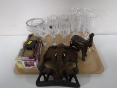 A tray containing carved hardwood elephant figures, die cast vehicles,