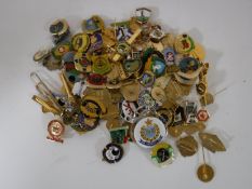 A box containing a collection of enamelled pin badges;