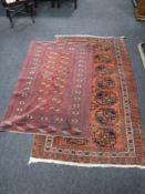 Two Afghan fringed rugs on red ground of geometric design