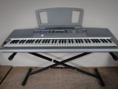A Yamaha portable grand DGX-200 electric keyboard on stand,