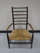 An antique rush seated ladder back armchair