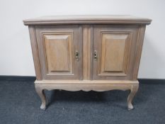 A continental oak double door sideboard on cabriole legs