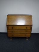 An oak writing bureau fitted three drawers