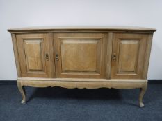 A continental oak triple door sideboard on cabriole legs