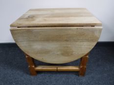 A blonde oak gate leg coffee table