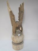 A carved wooden figure of a golden eagle