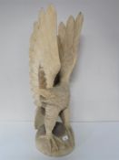 A carved wooden figure of a golden eagle