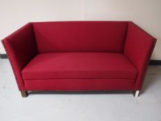An early twentieth century settee upholstered in a red button fabric