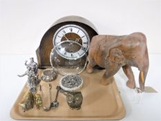A tray containing a carved hardwood elephant, a Anvil oak cased mantel clock, brass figures,