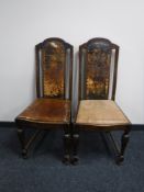 A pair of oak high backed dining chairs with a tooled leather inset panel