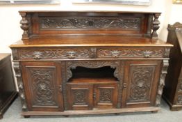 A late Victorian Green Man carved oak dresser,