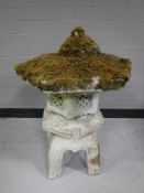 A concrete garden ornament in the form of a Chinese pagoda