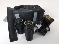 A camera bag containing a Cannon AV1 camera with flash,