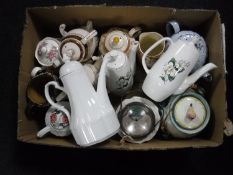 A box of china and pottery teapots, lidded biscuit barrels,