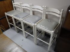 A set of four white bar stools